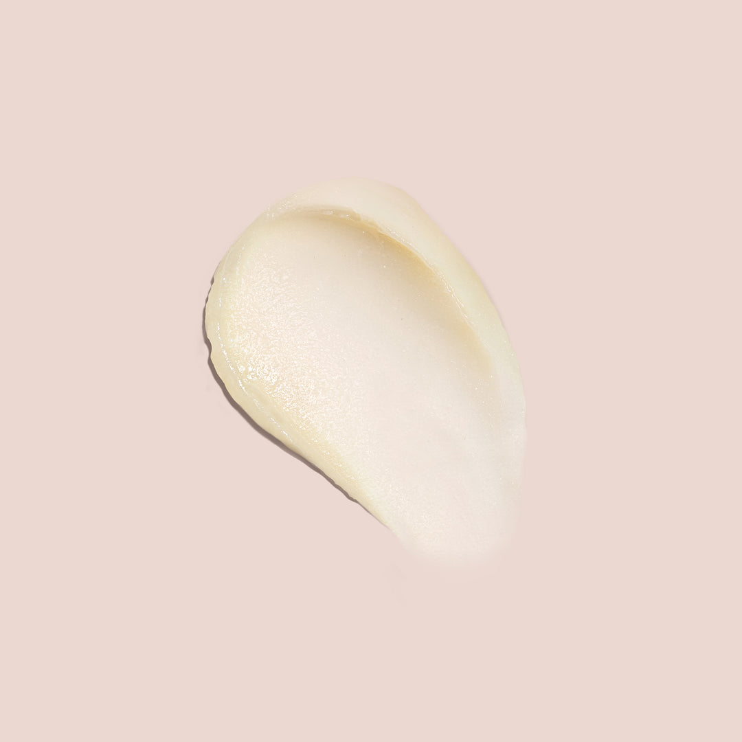 Balm under eyes swatch showing creamy, smooth texture on a soft nude background for skincare application visuals.