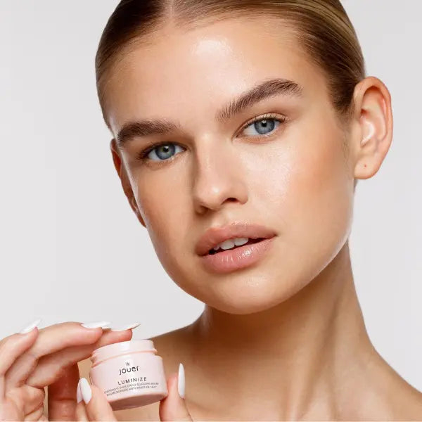 Brightening eye balm displayed by a model with fresh, radiant skin and natural makeup.