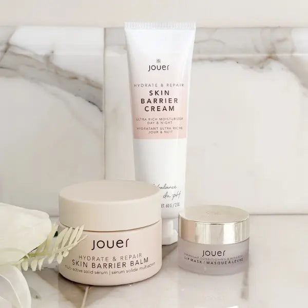 Plant-based wrinkle treatment products from Jouer including skin barrier balm, cream, and lip mask on marble background.