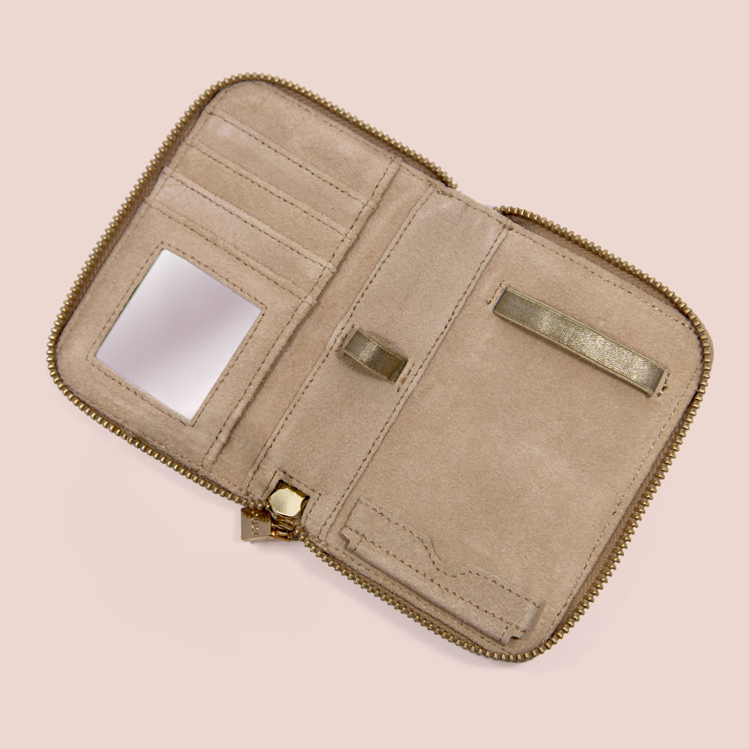 Open Petite Pochette travel case featuring interior card slots, mirror, brush holders, and storage compartments.