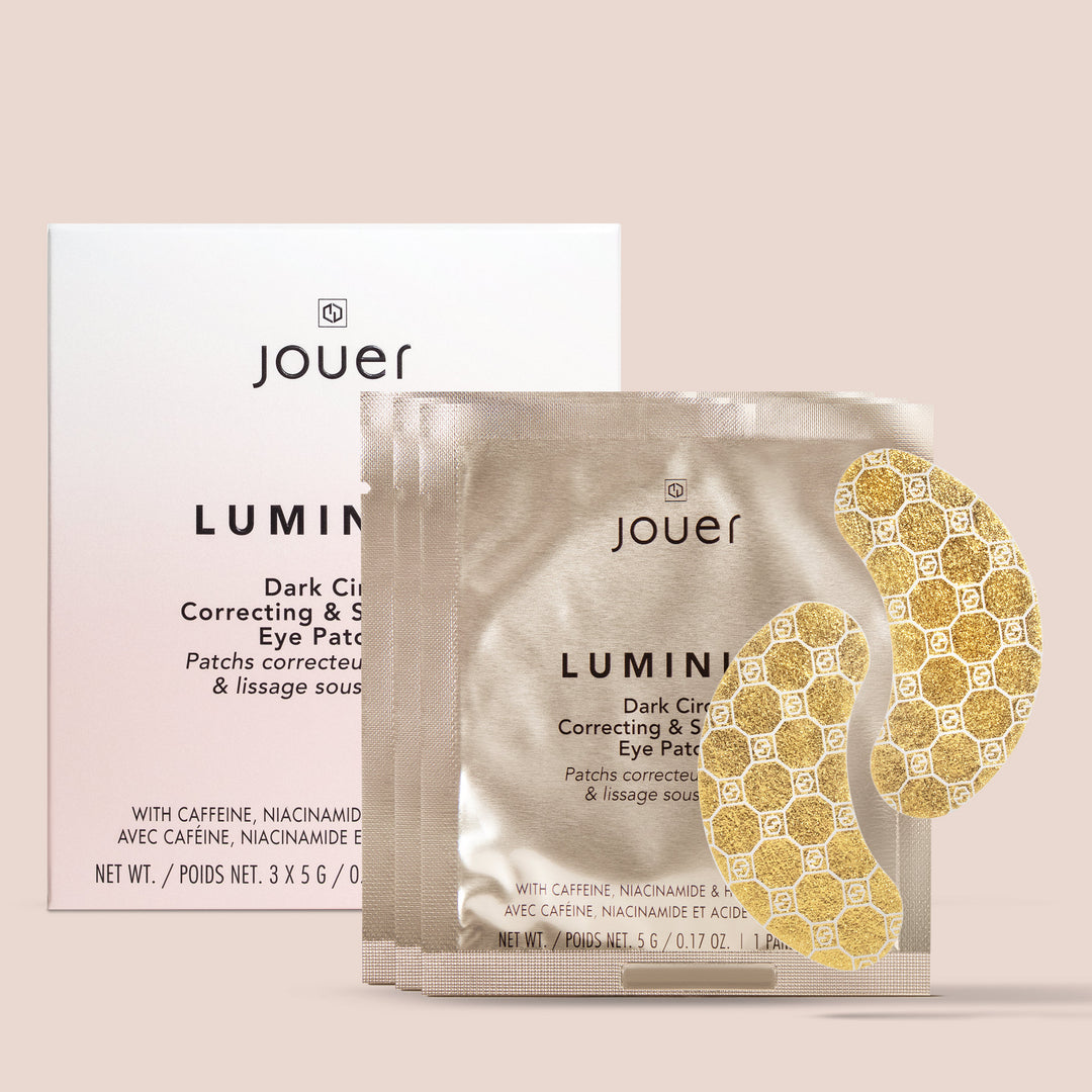Jouer Dark Circles Correcting & Sleeping Eye Patch set, featuring three individual silver foil pouches with gold emblem patterned eye patches in front of a white product box on a solid pale pink background.