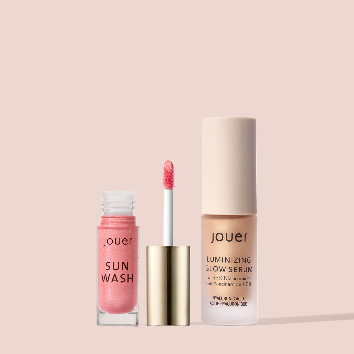Jouer Sun Wash Liquid Blush in Rosé Éclat with applicator and Luminizing Glow Serum in Nude Glow on a soft blush pink background.