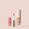 Jouer Sun Wash Liquid Blush in Rosé Éclat with applicator and Luminizing Glow Serum in Nude Glow on a soft blush pink background.