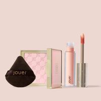 Jouer Brightening Essentials Set featuring pink brightening powder, powder puff, and light bright under-eye corrector with doe-foot applicator.