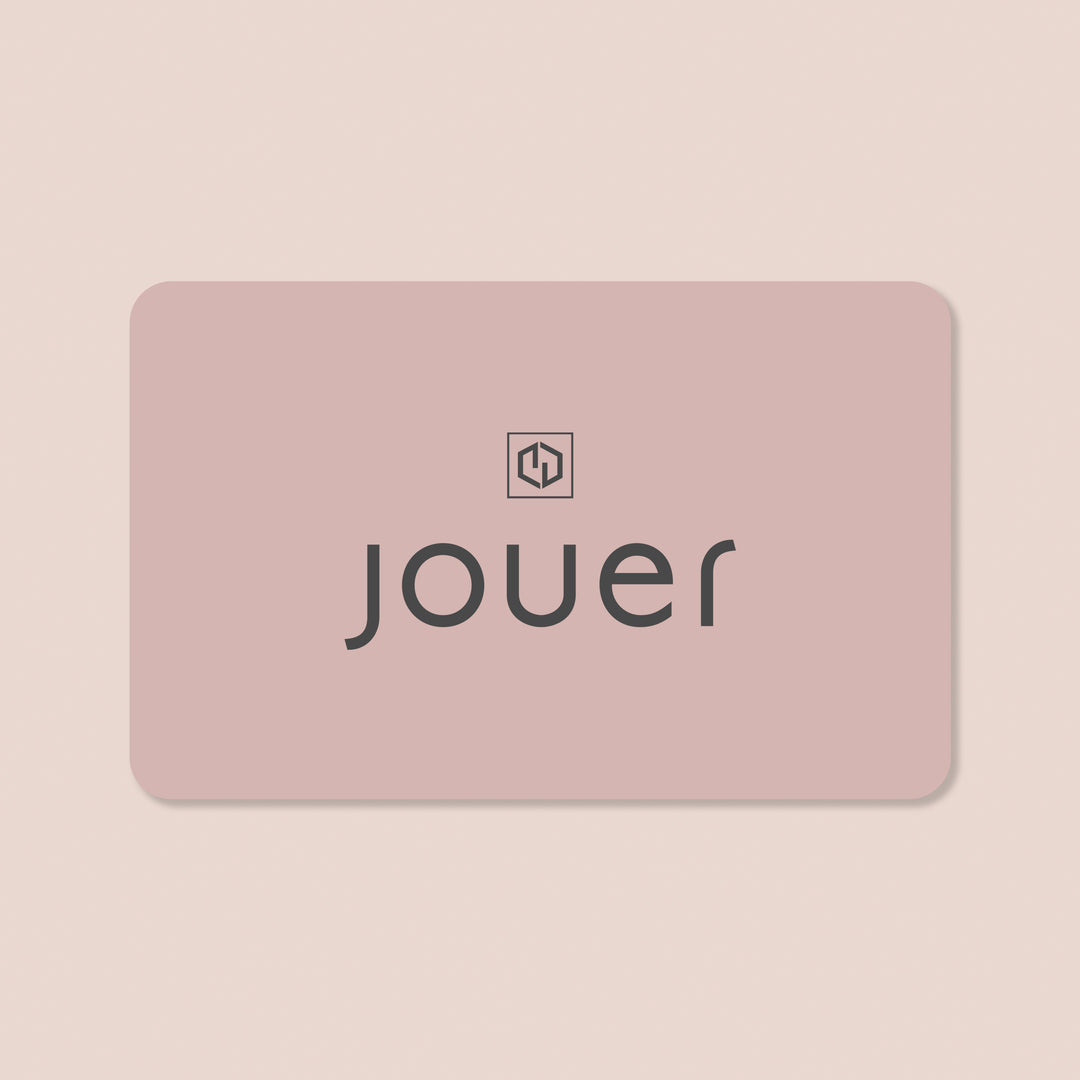 $100.00, alt:The Gift Card from Jouer Cosmetics features a rectangular design in a soft, light pink with rounded corners. "jouer" is displayed in lowercase black letters centered on the card, and above it sits a small black icon resembling a stylized, symmetrical letter "J" enclosed within a square. The background of the card is a gentle light beige.