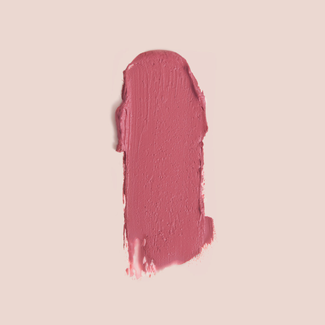 Rose lip and blush stick swatch in a creamy muted pink shade with a smooth, blendable texture on a nude background
