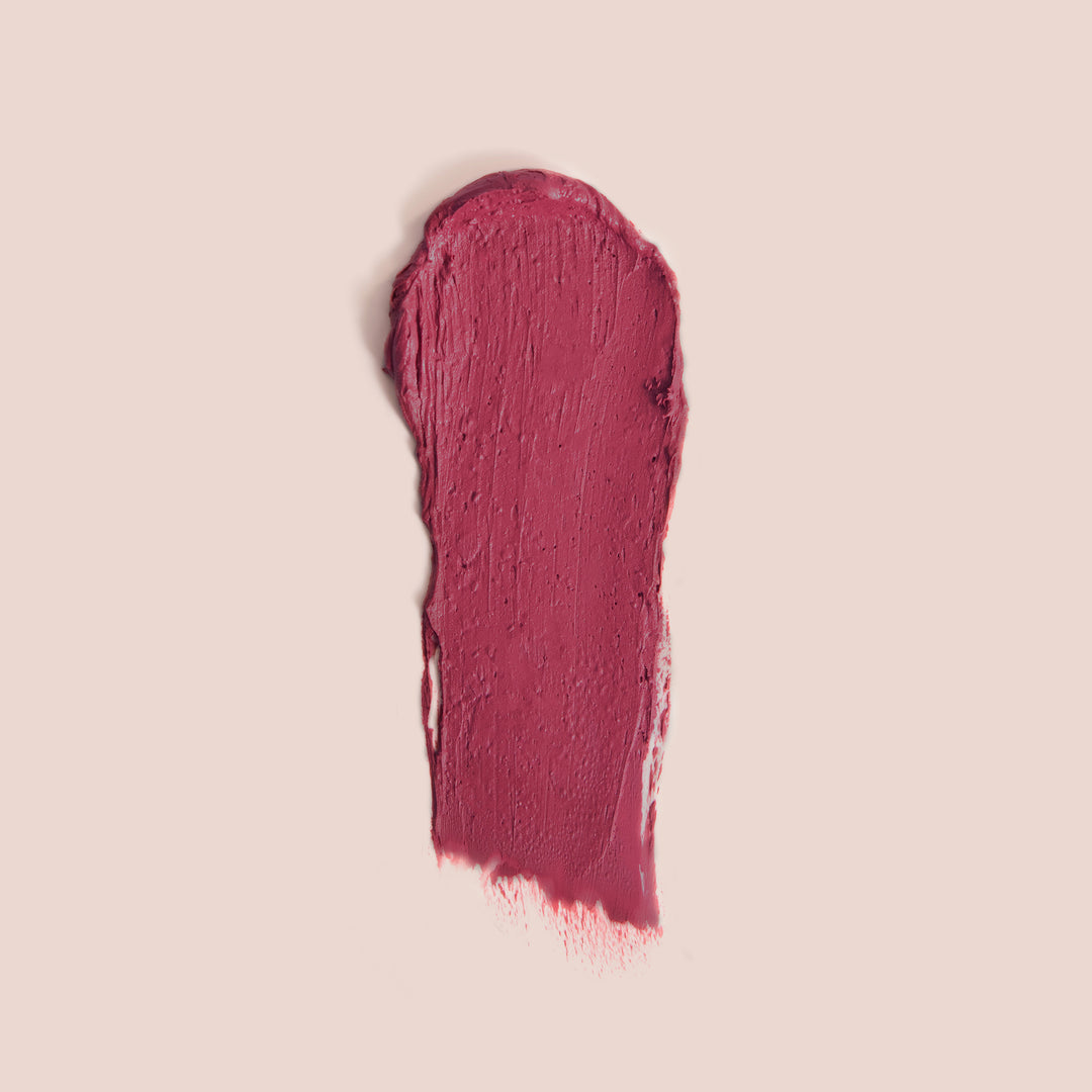 Bright rose lip cheek stick swatch in a bold, creamy shade with smooth texture on a soft nude background.