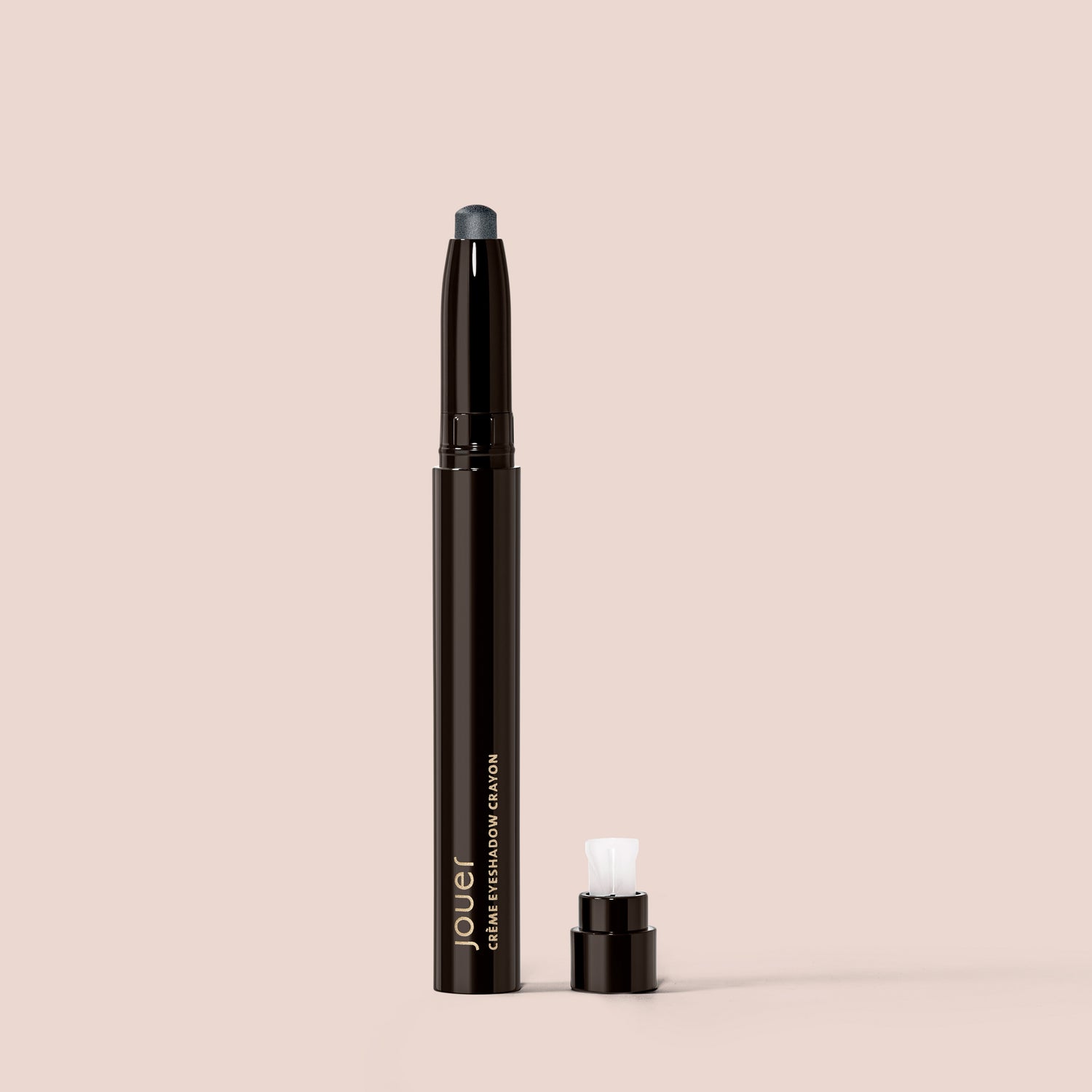 marble, alt: A Crème Eyeshadow pencil in Marble from Jouer Cosmetics, featuring a detachable cap, is set against a beige background. This cruelty-free pencil has a dark tip designed to define your eyelid, and it includes a white applicator positioned near the base next to the cap.