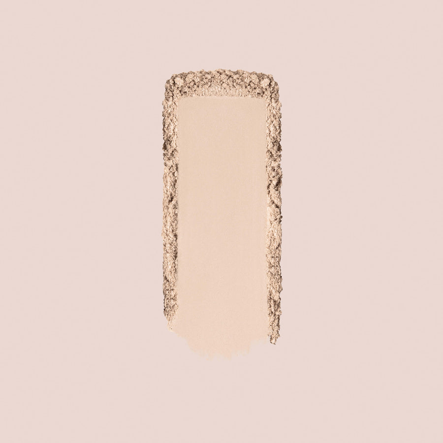 Beige setting powder swatch showing smooth application with textured powder edges on neutral background