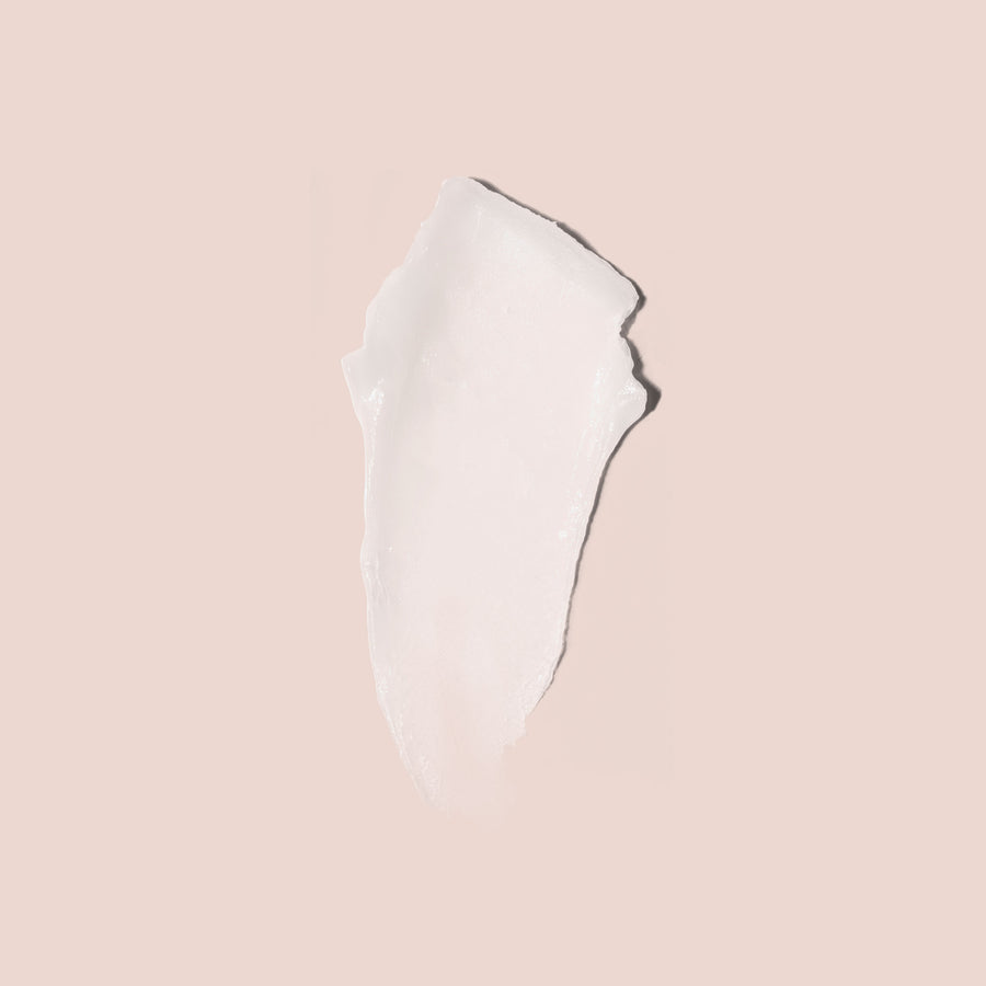 White creamy lip mask product swatch on pink background showing smooth texture