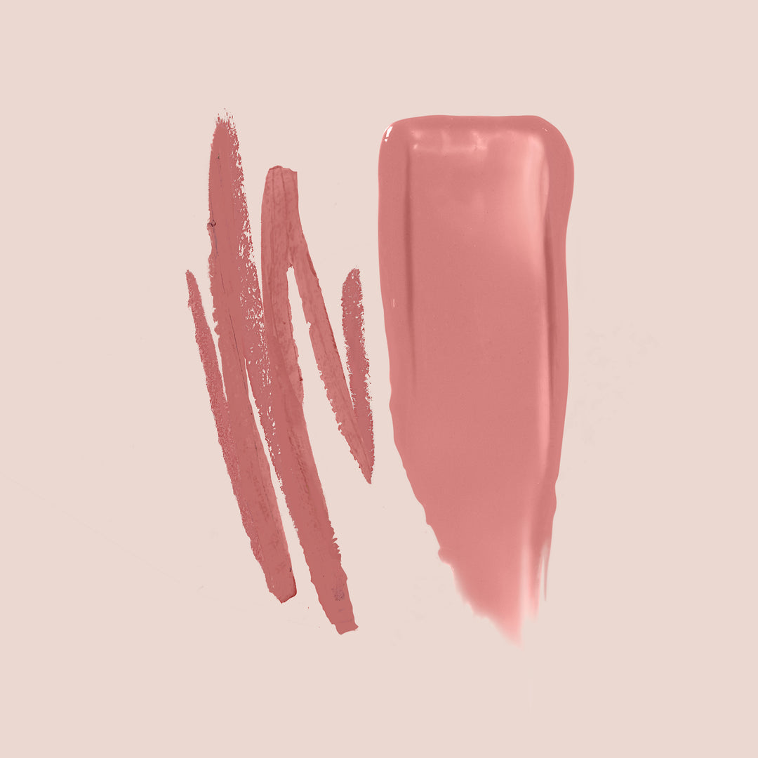 A swatch of the Bare Rose Lip Kit from Jouer Cosmetics, featuring pink lipstick and lip liner, displayed on a light beige background. The cruelty-free lip liner is applied in three rough strokes, while the lipstick is applied in a smooth, broad stroke, showcasing the texture and color of these products.