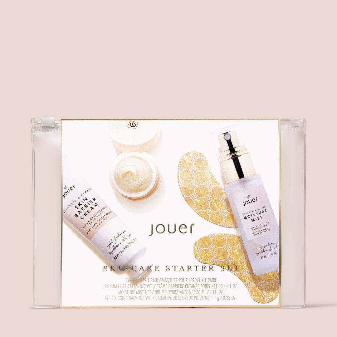 Image of the Jouer Cosmetics Skincare Starter Set, featuring a Skin Barrier Cream, Hydrating Face Mist, and Eye Smoothing Balm Net, all displayed against a light beige background. The set appears in simple, elegant packaging showcasing the products inside a clear cosmetic bag.