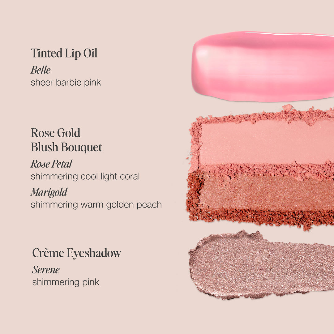 A beauty product display featuring swatches of three different makeup items from Jouer Cosmetics' Le Blush Set: Tinted Lip Oil in "Belle" (sheer Barbie pink), a Blush Bouquet with "Rose Petal" (cool light coral) and "Marigold" (warm golden peach), and a Crème Eyeshadow Crayon in "Serene" (shimmering pink).