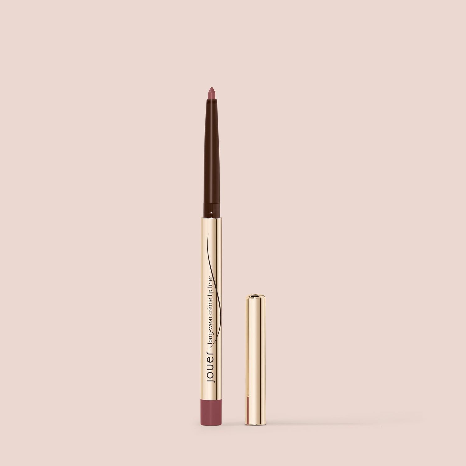 wild rose, A gold and brown, cruelty-free lip liner from Jouer Cosmetics stands upright against a beige background. The product is extended, revealing a brown pencil tip with its matching gold cap placed to the side. The brand name "Jouer" is visible on the paraben-free liner body.