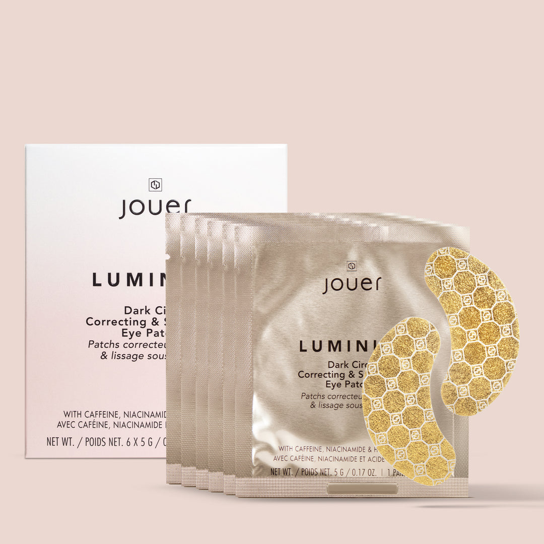 6 pack, Image of Jouer Cosmetics' Luminize Eye Patches. These golden, honeycomb-designed patches come in individual packets. The packaging highlights the vegan and cruelty-free formula, featuring key ingredients like caffeine and niacinamide for optimal results.