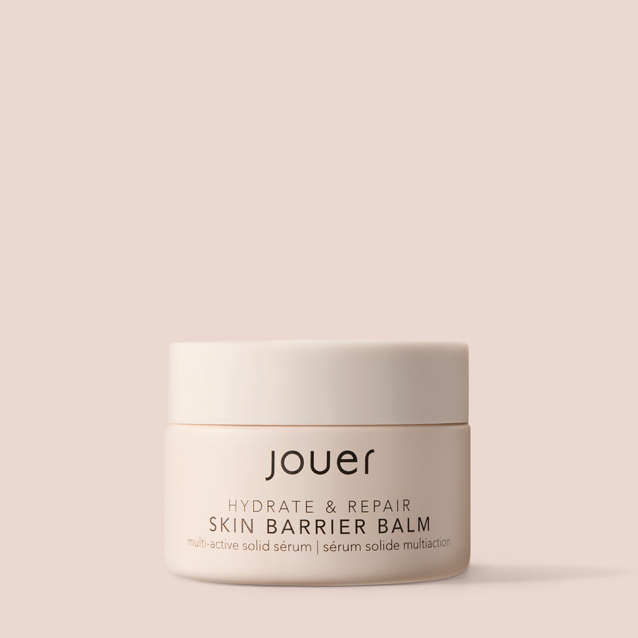 Balm for under eyes in a minimal beige jar labeled "Jouer Hydrate & Repair Skin Barrier Balm" on a soft nude background.
