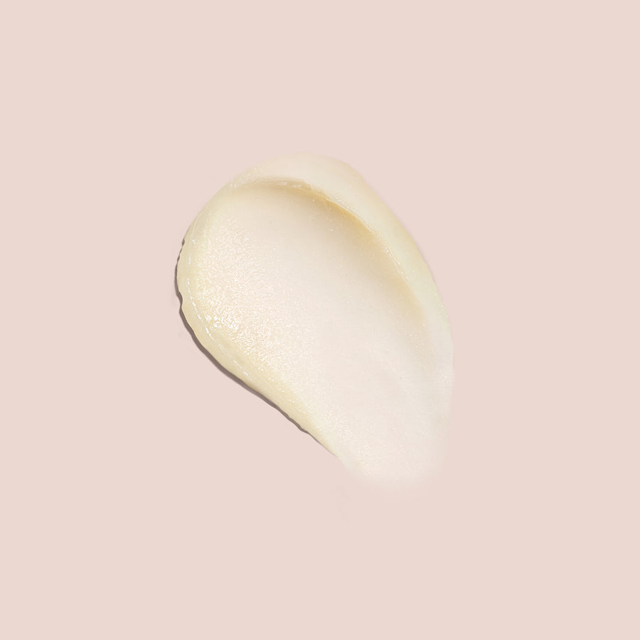 Balm under eyes swatch showing creamy, smooth texture on a soft nude background for skincare application visuals.