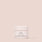 A small, round container of Cruelty-Free Luminize Under Eye Balm by Jouer Cosmetics is centered on a plain beige background. The white and rose gold packaging is minimalist, with the product name "LUMINIZE" prominently displayed on the front.