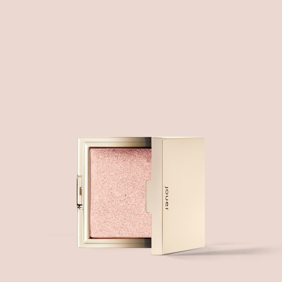 rose gold, full size alt: Rose gold, A gold compact highlighter case, partially opened, reveals a shimmery, light pink powder inside. The case has "Jouer Cosmetics" etched on its side and is proudly vegan. The background is a solid light beige color.