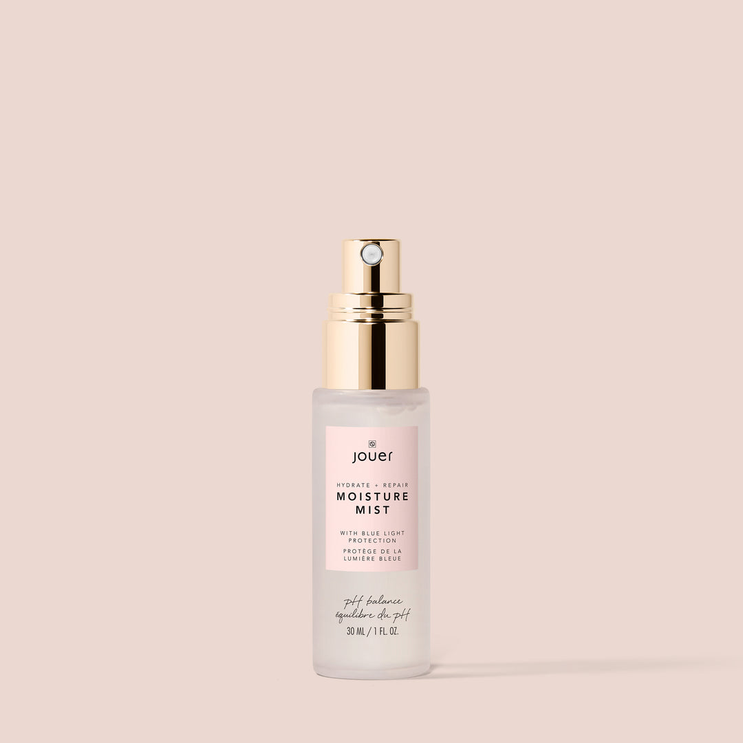 Jouer Moisture Mist spray bottle with gold pump and clear glass against pink background